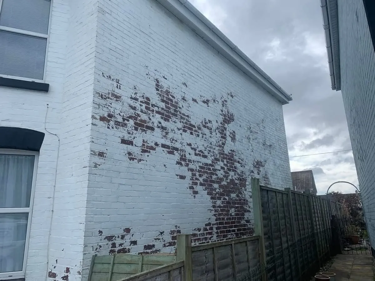 Peeling paint on a brick wall before redecoration in Liskeard